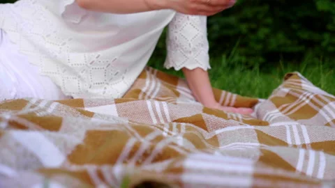 Close up little boy puts fruit basket and croissant on plaid, sits down Stock Footage 133992709