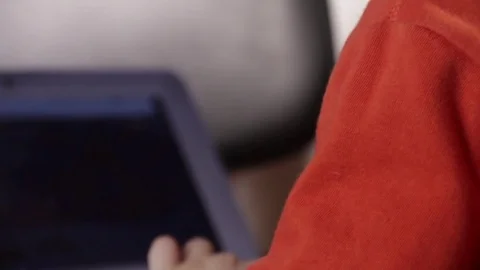 Close up of a little boy sitting on the floor and trying to learn with a Stock Footage 75347771