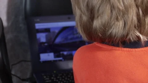 Close up of a little boy sitting on the floor and trying to learn with a Stock Footage 75347928