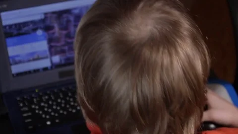 Close up of a little boy sitting on the floor and trying to learn with a Stock Footage 75347932