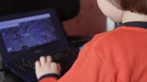 Close up of a little boy sitting on the floor and trying to learn with a Stock Footage 75348246