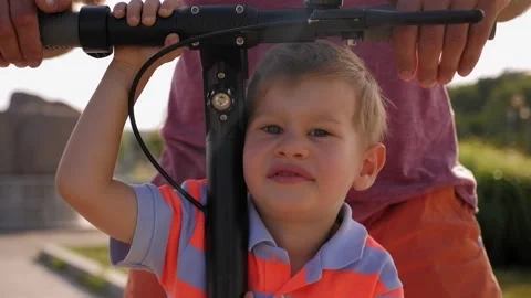 Close-up of a little boy's face on an electric scooter with his father. Stock Footage 158658917