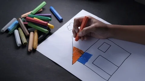 Close up of little girl is coloring a home figure in crayons Stock Footage