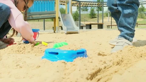 Close-up of little girl playing with molds in sand on the beach, slow motion. Ha Stock Footage 279071253