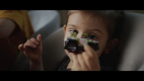 Close-up of a little girl standing next to her brother at a table full of toys Stock Footage 273304053