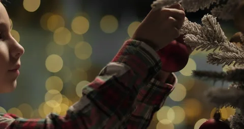 Close-up little kid boy decorating Christmas tree with balls Stock Footage 294092036