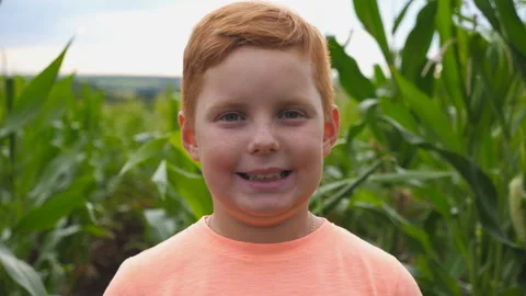 Close up of little smiling red-haired boy with freckles looking into camera Video stock 135397255