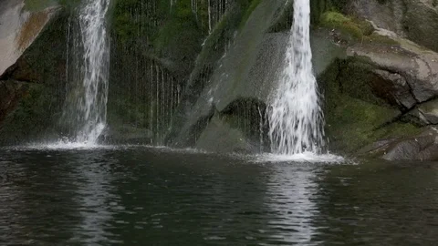 Close up of a little waterfall hitting the rocks and falling into the water Stock Footage 125096173