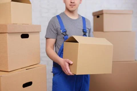 Close up of loader holding a box in warehouse or post office Stock Photos