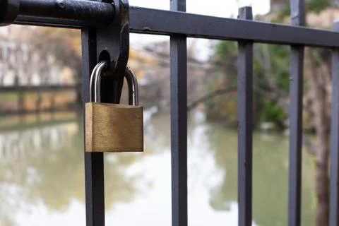 Close-up of a lock closed on a gate with river background on a cloudy day Stock Photos