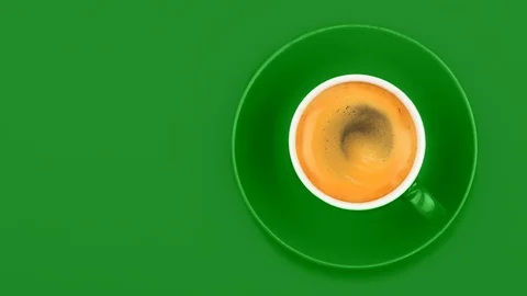 Close-up lockdown shot of cup of hot coffee against green background Stock Footage 114846608