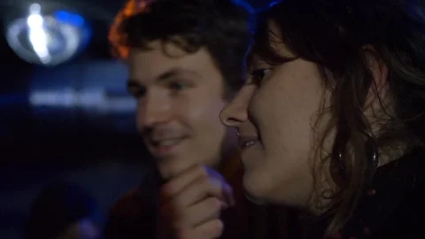 Close-up lockdown shot of two young people talking to each other at party Video stock 114874861