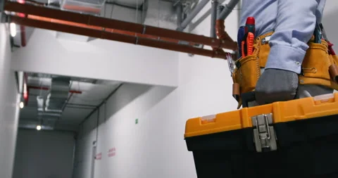 Close-up, a locksmith appears in the video with tools on his belt and a suitcase 動画素材 252208304