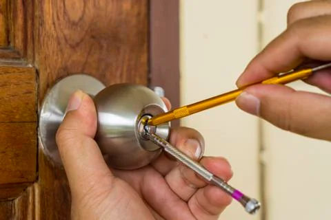 Close-up locksmith try to open the old wood door Stock Photos