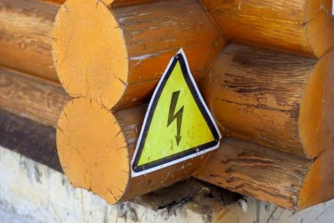 Close-up of log house. Corner of old wooden house with yellow metal sign with Stock Photos