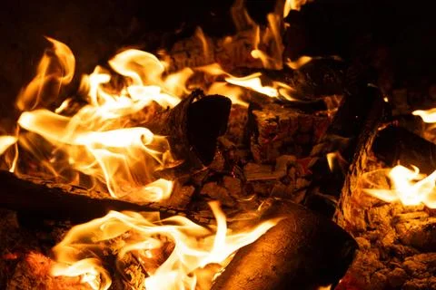 Close-up of Logs Burning with Intense Yellow and Orange Flames. Stock Photos