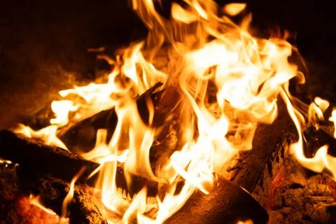 Close-up of Logs Burning with Intense Yellow and Orange Flames. Stock Photos