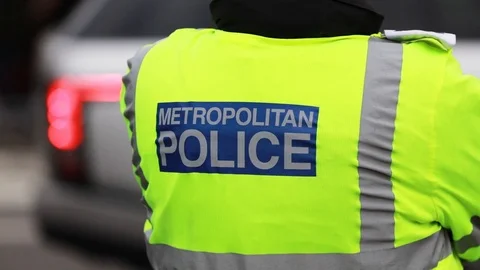 Close up of a London Metropolitan Police officer wearing a high visibility Stock Footage