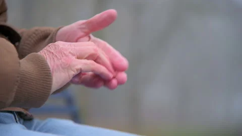 Close on Lonely Elderly Man Rubs Hands Together With Worry  Stock Footage 147873132