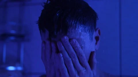 Close-up of lonely man under a hot shower, covering his face, feeling numb and Stock Footage 311451511