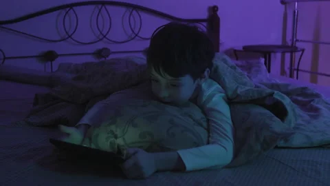 Close Up Of Lonely Young Boy Lying In Bed And Using Smartphone At Night. Young Video stock 154027644