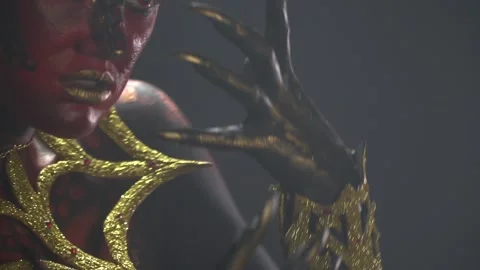 Close up of the long nails on a black and gold hand of a demon woman Stock Footage 138139930