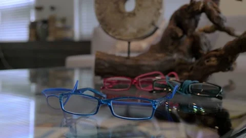 A close up look at the blue glasses lying on the table alongside red glasses Stock Footage 147937128