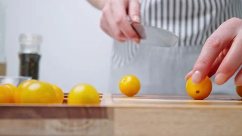 A close-up look of chopping yellow tomatoes on a wooden cutting board. Stock Footage 142114451