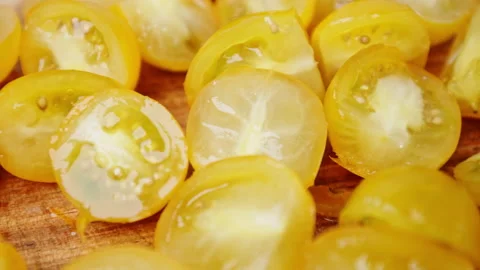 A close-up look of chopping yellow tomatoes on a wooden cutting board. Stock Footage 142114597