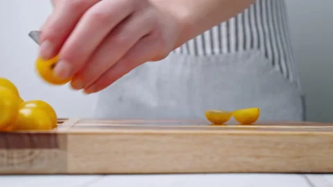 A close-up look of chopping yellow tomatoes on a wooden cutting board. Stock Footage 142114642