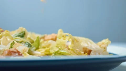 A close-up look of female hands serving with a fork fresh Caesar Salad in 4K. Stock Footage 140770096