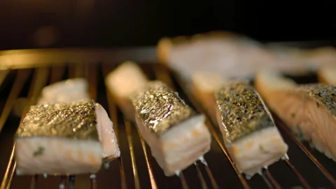 A close-up look of fillets of salmon being cooked in the oven in the grill. Video stock 132815587