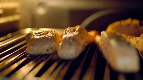 A close-up look of fillets of salmon being cooked in the oven in the grill. Video stock 132816091