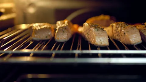 A close-up look of fillets of salmon being cooked in the oven in the grill. Stock Footage 132816364