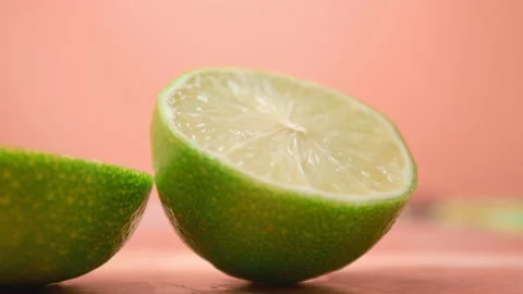 A close-up look of a fresh lime being cut in half on a cutting board in 4K. Stock Footage 141309368