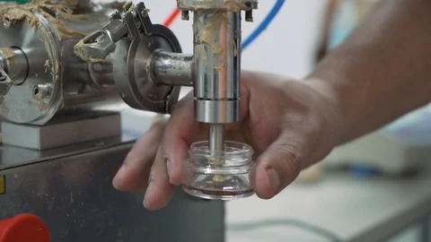 Close look of machine filling small jar and Scientist measuring it on electronic Stock Footage 116610578