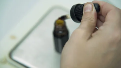 Close look of Scientists hand using Dropper and filling bottle with Stock Footage 116611008