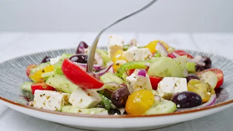 A close-up look of serving with a fork freshly made vibrant Greek Salad. Stock Footage 142117986