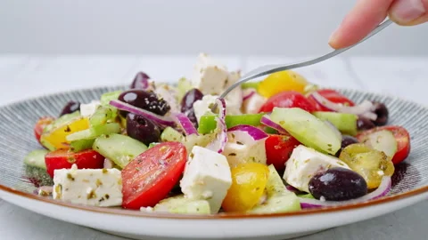 A close-up look of serving with a fork freshly made vibrant Greek Salad. Stock Footage 142117997