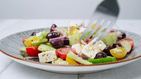 A close-up look of serving with a fork freshly made vibrant Greek Salad. Stock Footage 142118082
