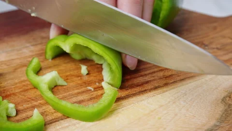 A close-up look of slicing and chopping a Green Bell Pepper on a cutting board. Stock Footage 142113634