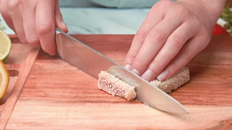 A close-up look of slicing fried Seared Tuna on cutting board in 4K. Stock Footage 141309747