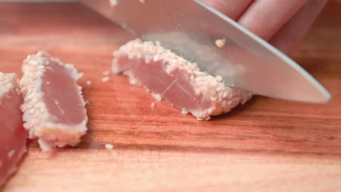 A close-up look of slicing fried Seared Tuna on cutting board in 4K. Stock Footage 141309766