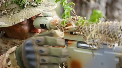 Close-up. Looking through the sniper scope and reloads rifle. Ghillie suit. Stock Footage 127637633