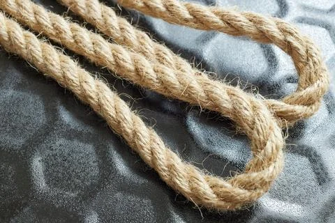 Close-up of a looped string of twine on black, suggesting continuity and cycl Stock Photos