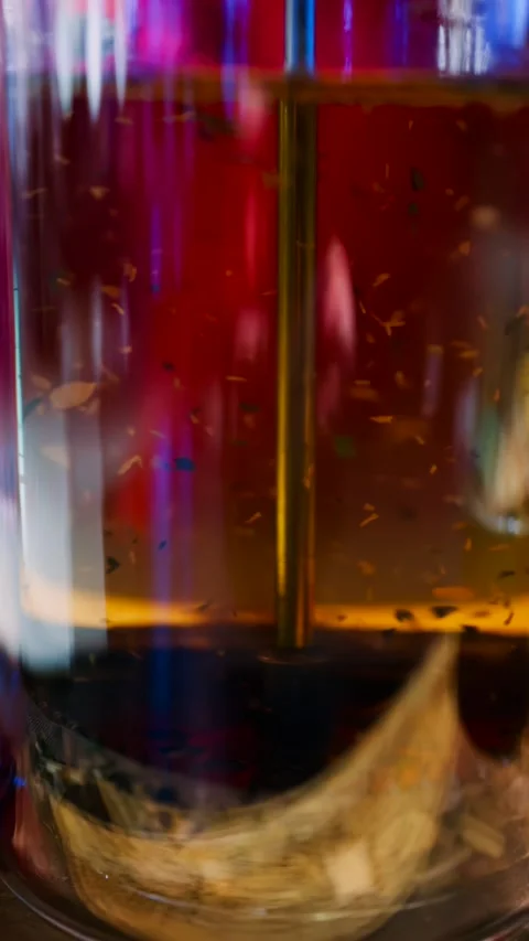 Close-up of loose leaf tea steeping in hot water within a clear glass teapo.. Stock Footage 339342808