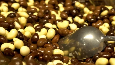 Close-up of a lot of delicious nuts in white black bitter and milk sweet chocola Stock Footage 122923183