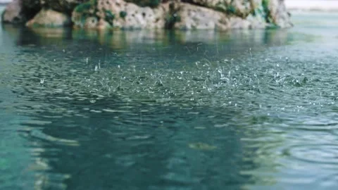Close-up a lot of raindrops quickly fall on the surface of the blue flower water Stock Footage 212421159
