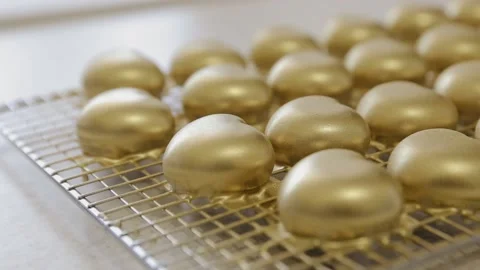 Close up of lots heart shaped cakes with gold color edible coating. Cakes for Stock Footage 134345425