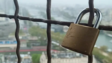 Close-up of a love lock on a railing with a blurred view of Paris, France Stock Footage 342435447